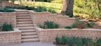 Lush gardens border this driveway thanks to tiered planters built ...