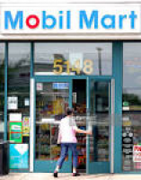 A woman enters a Mobil Mart at a Mobil gas station in Chicag ...